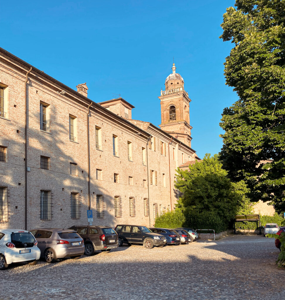 Das alte Kloster in der Frontansicht mit dem Parkplatz im Vordergrund.